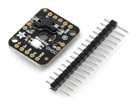 A module with a socket for a mechanical switch in black color lies on a white background along with a set of pins.