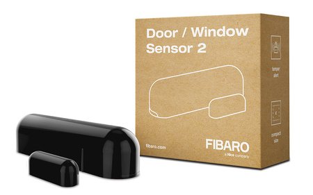 The black Fibaro smart door and window opening sensor lies on a white background with a box.